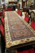 A Persian runner, blue ground with geometric lozenge shaped panels.