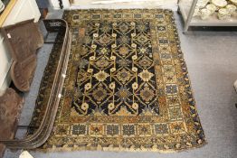 A Persian rug, dark blue ground with geometric decoration, within a similar border.