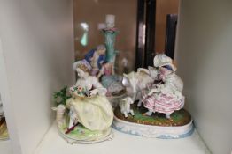 Three decorative porcelain figure groups.