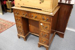 A reproduction mahogany kneehole desk.