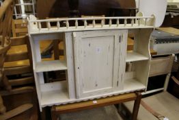 A painted single door hanging shelf unit.