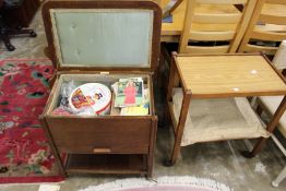 An oak sewing trolley with numerous sewing items including threads, patterns, a large quantity of