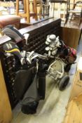 Two sets of golf clubs and a golf trolley.