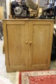 A pine two door cupboard.