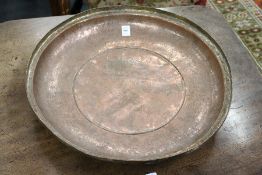 An engraved copper circular bowl.