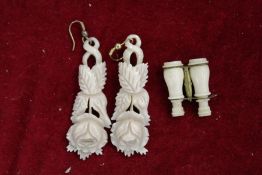 A miniature ivory model of binoculars and a pair of carved bone earrings.