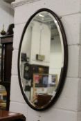 An oval mahogany framed wall mirror.