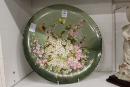 A 19th century circular charger painted with flowers and butterflies, signed to the reverse Alice