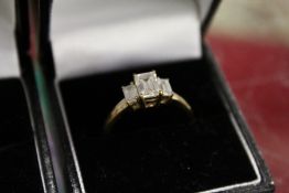 A 9ct gold ring set with three emerald cut stones.