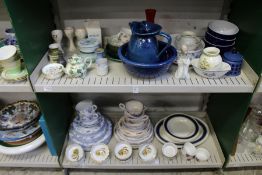 Two shelves of part dinner services and other decorative china.