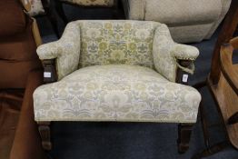 A small Edwardian square shaped upholstered armchair.