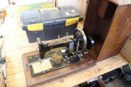 A Frister and Rossmann sewing machine and a box of tools.