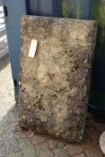 A large rectangular heavy weathered stone plinth.