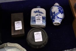Two Chinese porcelain snuff bottles with associated stands.