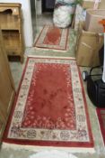 Two small Chinese red ground rugs.