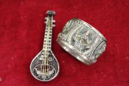 A small filigree model of a lute together with a napkin ring.