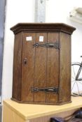 A small oak hanging corner cupboard.