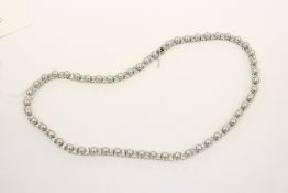 A decorative silver necklace set with pearls.