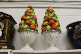 A pair of painted plaster ornaments modelled as vases filled with fruit.