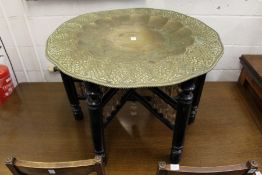 An Islamic brass try table with ebonised folding stand.