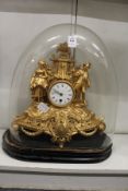 A French gilt spelter mantle clock under an associated glass dome.