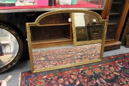 An arch shaped gilt framed mirror.