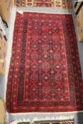 A Persian red ground rug with geometric decoration.