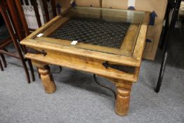 A hardwood, wrought iron and glass topped coffee table.