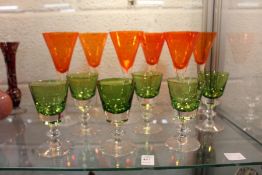 A set of six Val St Lambert wine glasses and a set of six orange wine glasses.