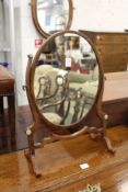 An oval dressing table mirror.