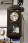 An oak cased drop dial wall clock.
