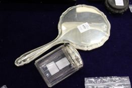 A silver backed hand mirror and silver topped cut glass dressing table jar.