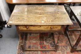 A 18th century oak side table with drawer on turned supports.