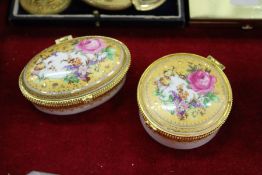 Two enamel boxes with ormolu mounted hinged covers, decorated with flowers.