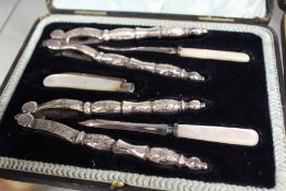 A cased after dinner set comprising nutcrackers with picks and a silver and mother-of-pearl fruit