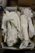 A quantity of christening gowns.