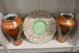 A Shelley floral decorated charger and a pair of Carlton ware lustre decorated vases (faults).