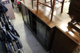 Two oak oak bookcases with glass sliding doors.