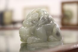 A Chinese carved celadon jade figure of a mythical beast or dragon.