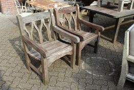 A pair of teak garden armchairs.