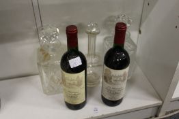 Two bottles of claret and three glass decanters.
