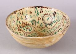 A GOOD IRAN STYLE POTTERY BOWL, decorated with green & biscuit grounds, carved with the view of a