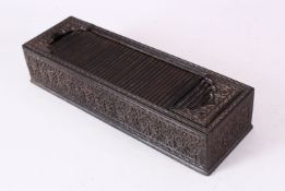 A GOOD 19TH CENTURY INDIAN CARVED EBONY RECTANGULAR PEN BOX, with tambour cover, the sides finely