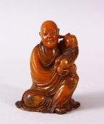 A GOOD 18TH / 19TH CENTURY CHINESE CARVED SOAPSTONE FIGURE OF ROHAN, in a seated position with a dog
