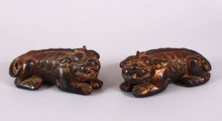 TWO CHINESE BRONZE FIGURES OF LION DOGS, each gilded with traced of red lacquer, in recumbent