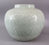 A LARGE CHINESE MING STYLE CELADON CARVED GINGER JAR, decorated with carved lotus and flora with