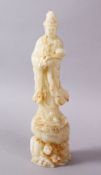 A CHINESE CARVED WHITE JADE FIGURE OF GUANYIN, stood uon a rocky outcrop holding a ruyi sceptre,