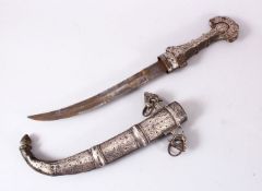 A GOOD EASTERN WHITE METAL JAMBIYA DAGGER, with onlaid white metal decoration, with han dles and