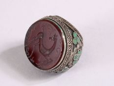 AN INDIAN SILVER INLAID INTAGLIO STYLE RING, the top carved with a horse, the sides with inlaid