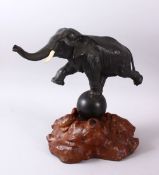 A JAPANESE MEIJI PERIOD BRONZE ELEPHANT & STAND, the elephant stood balancing upon a ball, upon a